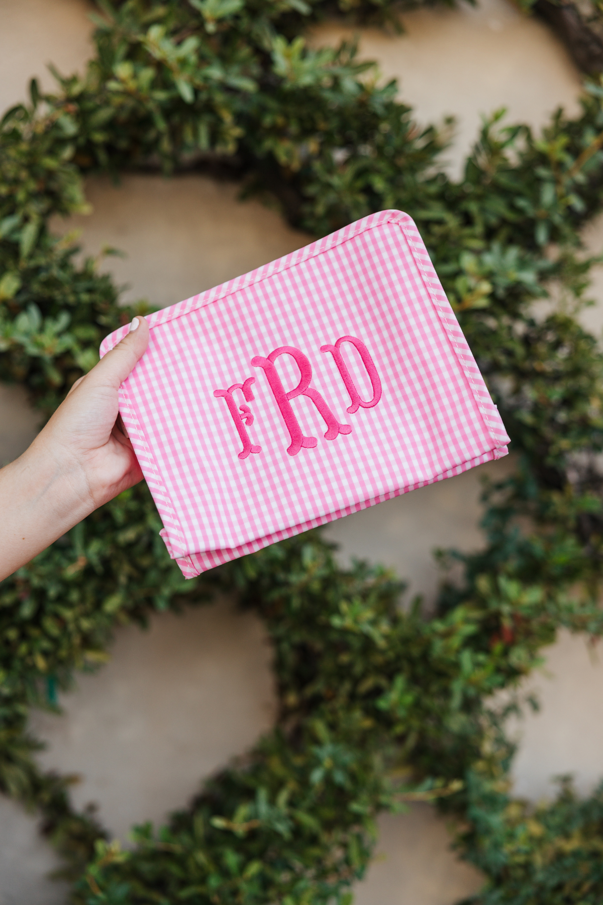 Pink gingham pouch with 'FRD' monogram embroidered in pink.