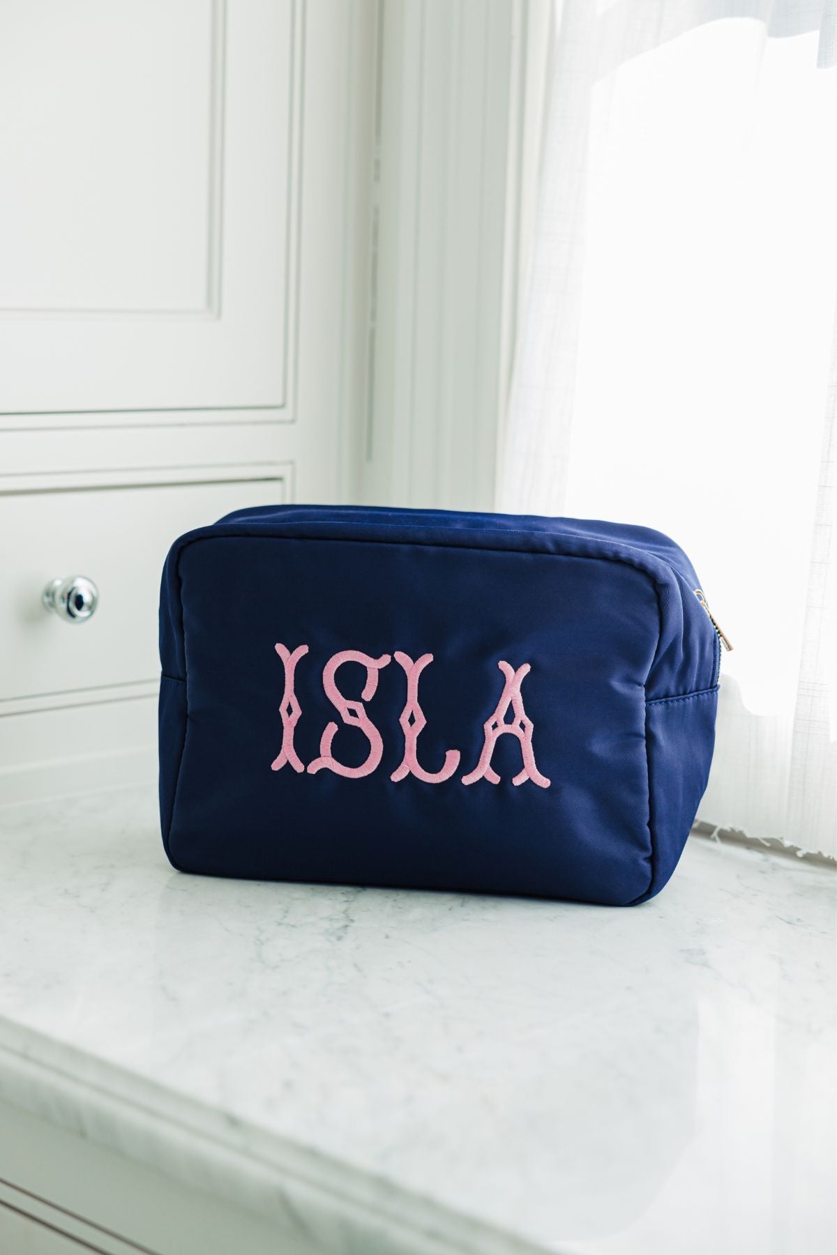A navy blue rectangular toiletry bag with a zippered closure