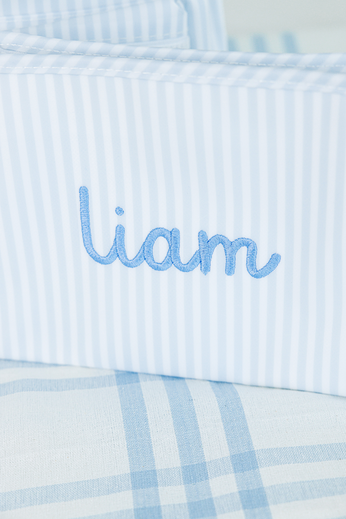 Close-up of a personalized striped pouch embroidered with the name "Liam"