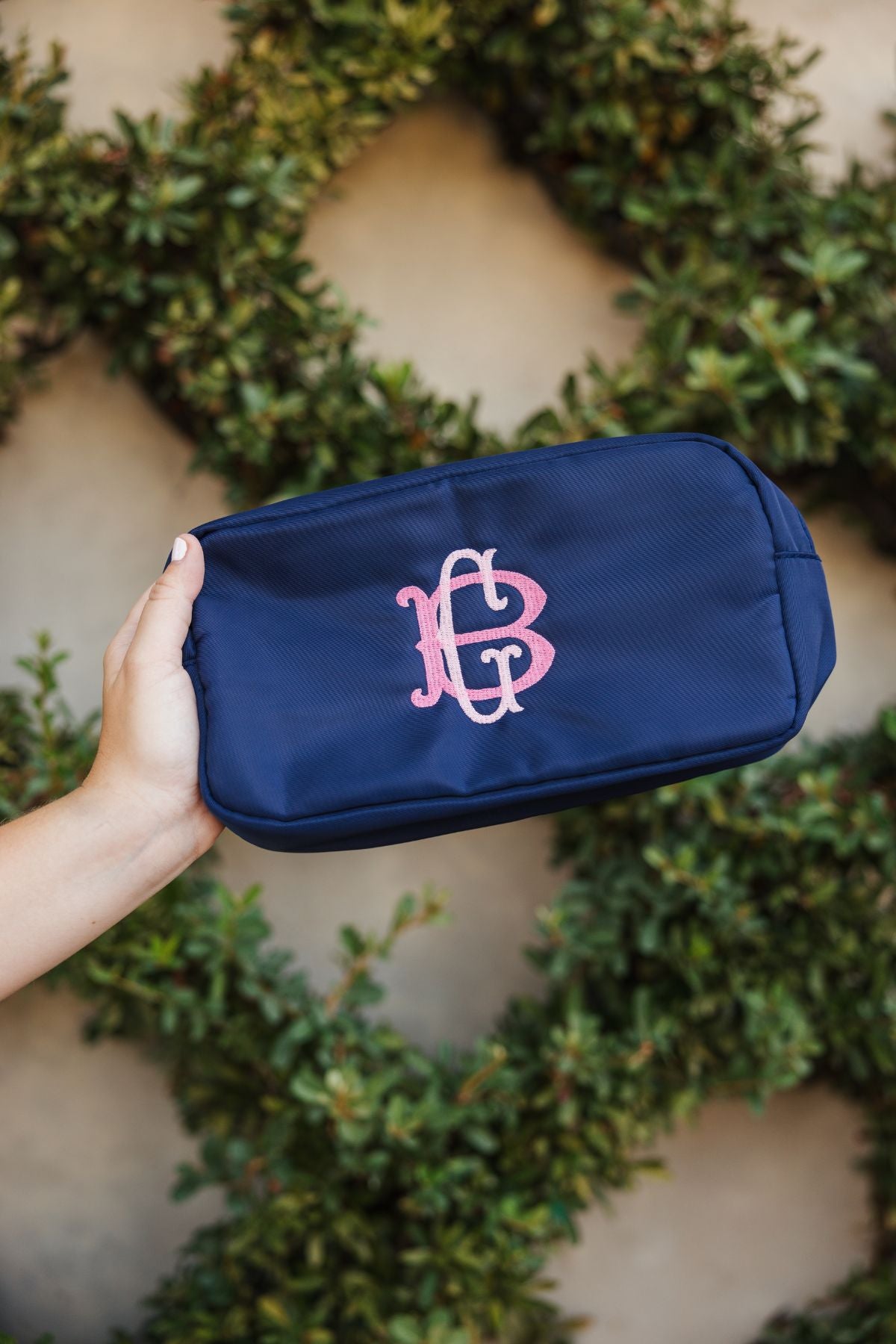 Navy blue bag with a rectangular shape, featuring a zippered closure and textured fabric