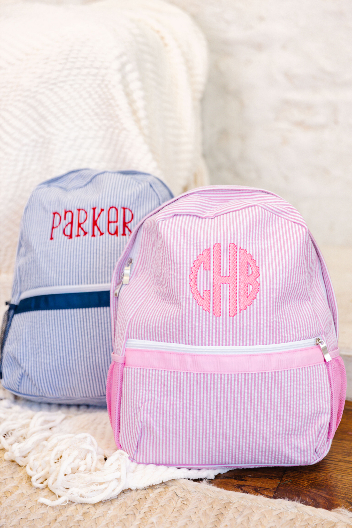 Pink striped backpack and blue striped backpack with monogram.