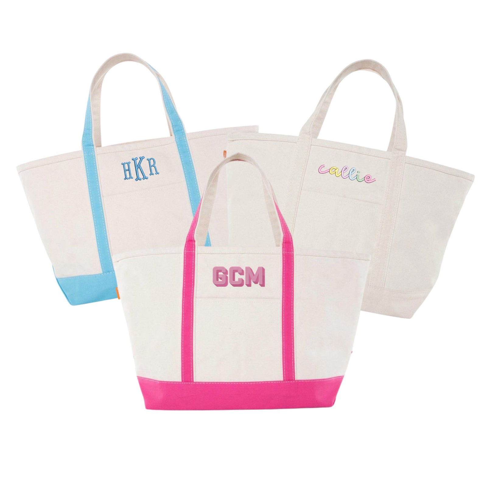 Three personalized canvas tote bags with colored straps and bottom accents