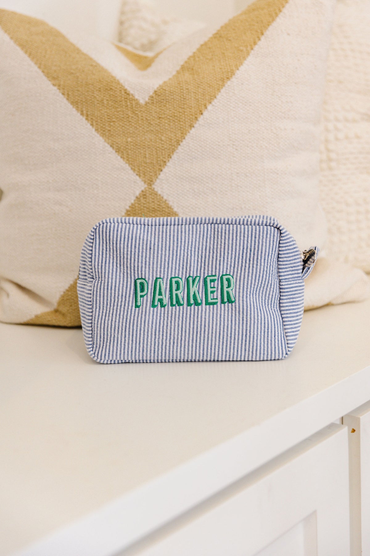 Blue striped pouch with 'Parker' embroidered in green.