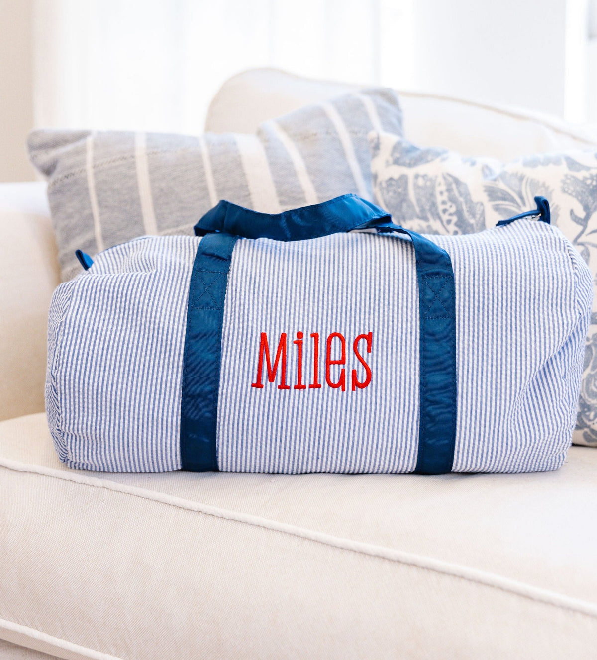 Blue striped duffel bag with 'Miles' embroidered in red