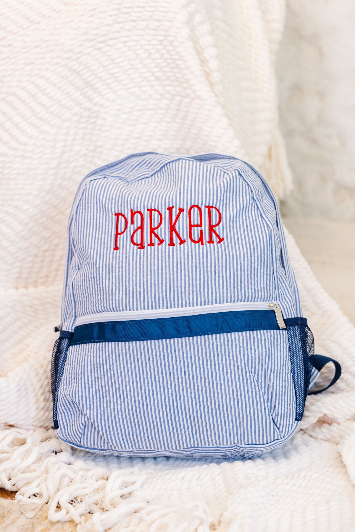 Blue striped backpack with 'Parker' embroidered in red
