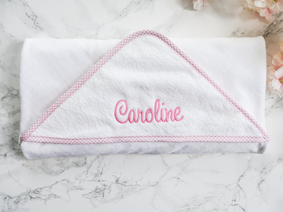 White hooded towel with pink gingham trim and 'Caroline' embroidered in pink