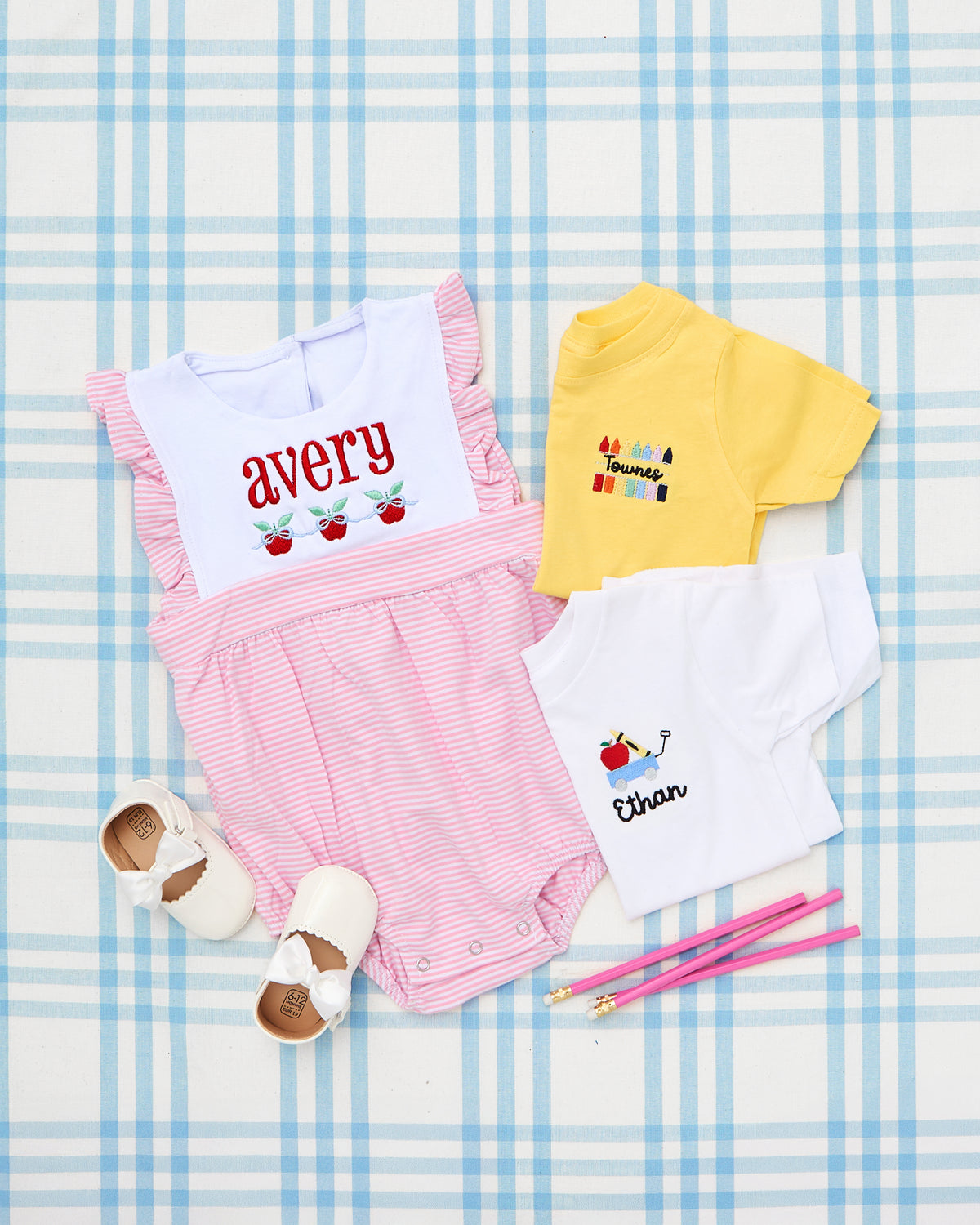 Charming Sleeveless Striped Bubble featuring delicate pink and white stripes with flutter sleeves and a crisp white bib, beautifully embroidered with the name "avery" and sweet strawberry motifs. Perfect for a personalized and playful summer look for little girls.