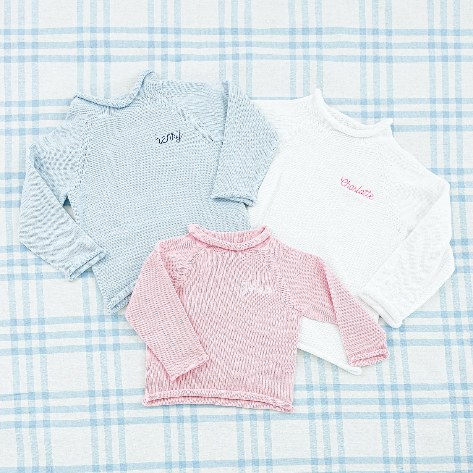 Pink and blue baby sweater personalized with the name.