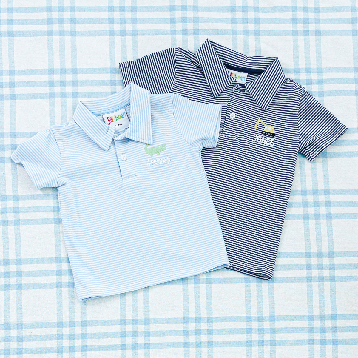 Two personalized baby polo shirts, one in light blue and the other in navy, both featuring subtle stripes and embroidered designs on the chest.