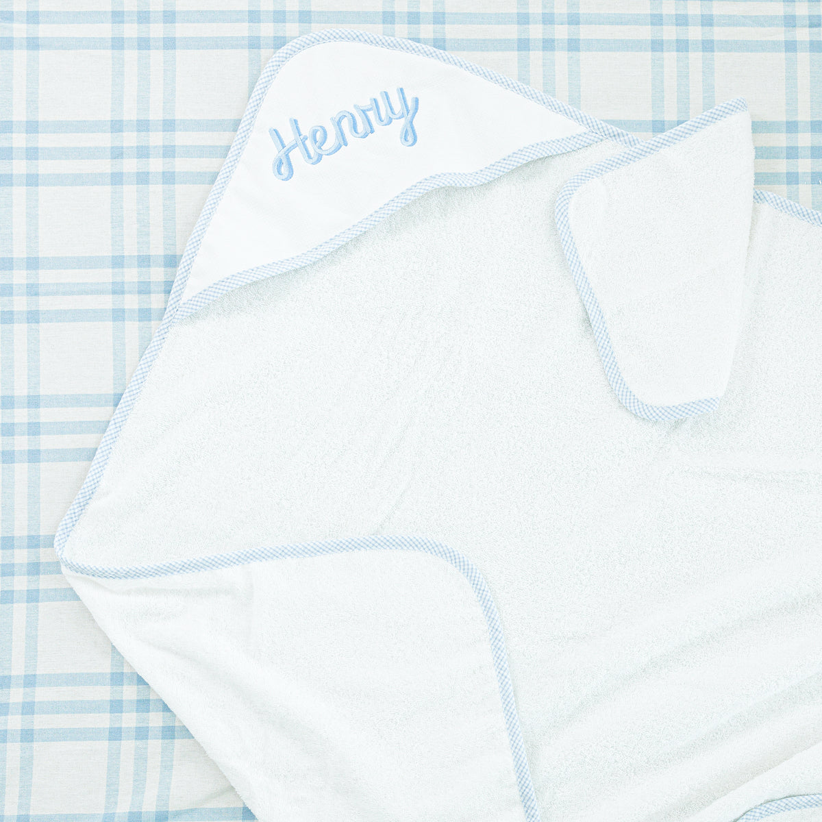 White hooded towel with light blue trim, personalized with the name 'Henry' embroidered on the hood