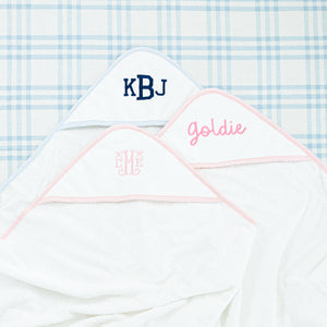 Three white hooded towels with personalized embroidery featuring the initials 'KBJ', 'Goldie', 'CME'.