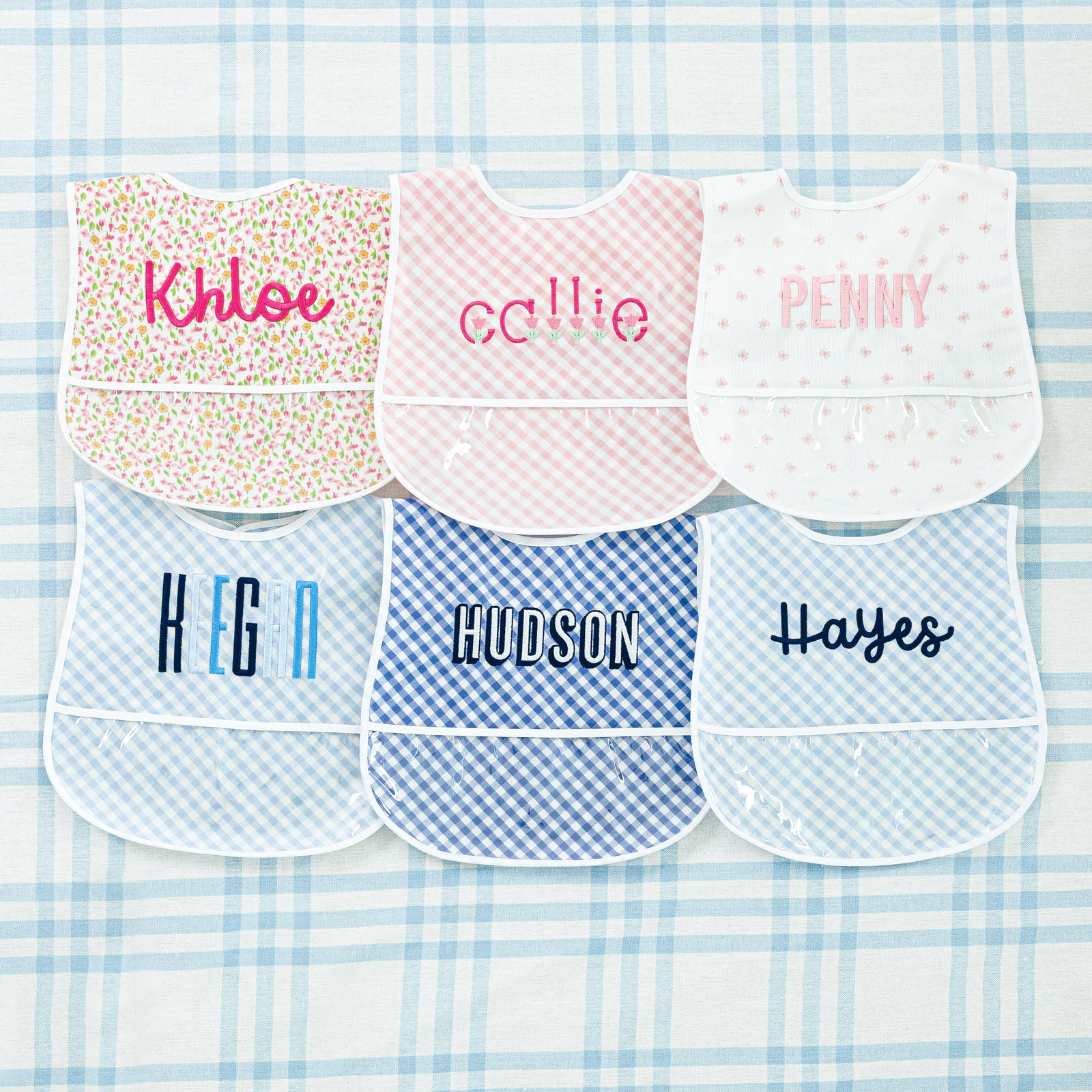 Set of two laminated baby bibs featuring gingham and floral pattern