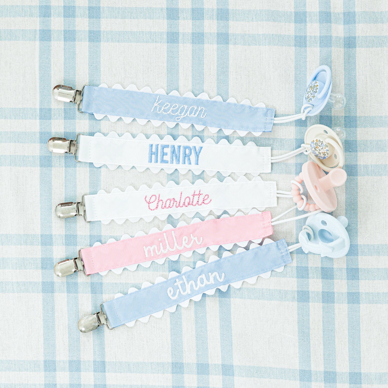Set of three pastel-colored pacifier clips with rickrack trim.