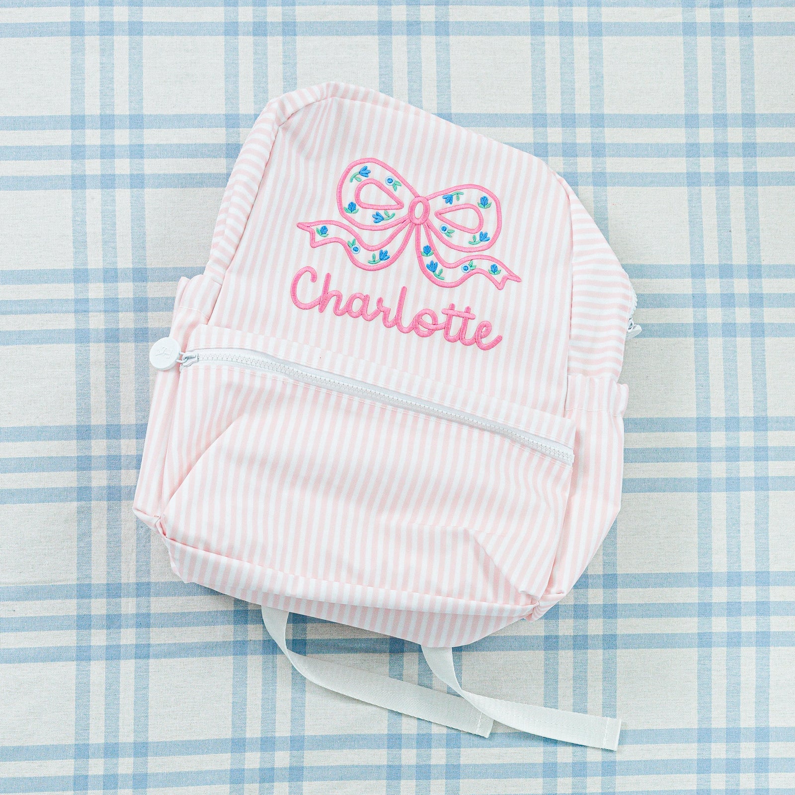 Personalized backpacks: a blue-striped backpack and a pink-striped backpack.