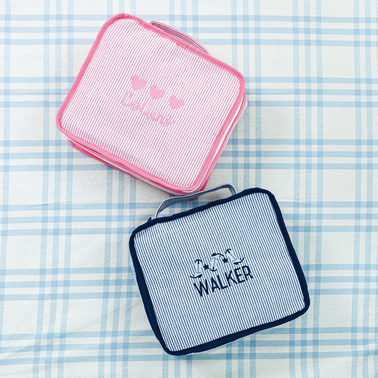 Three pink seersucker pouches with bow designs and the name 'Charlotte' embroidered in pink.