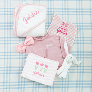 A personalized baby gift set all embroidered with the name 'Goldie'.
