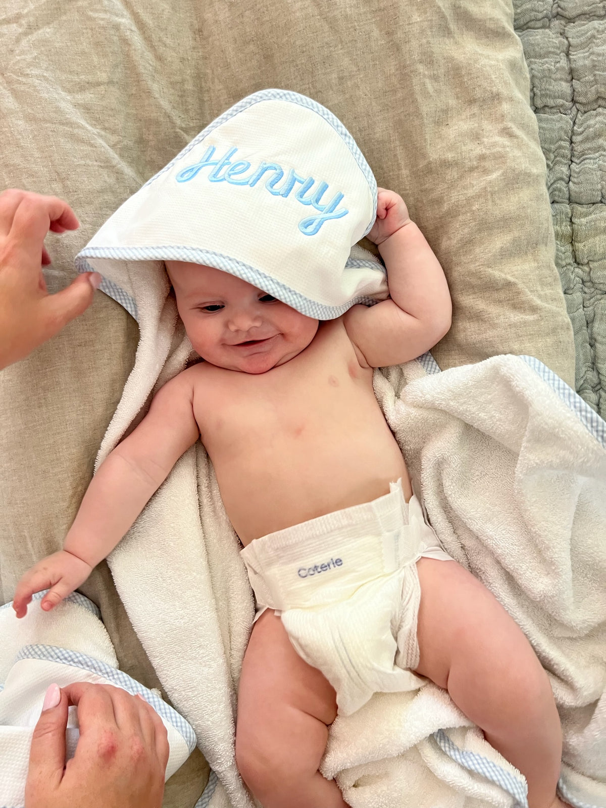 White hooded towel with light blue trim and 'Henry' embroidered in blue on the hood.