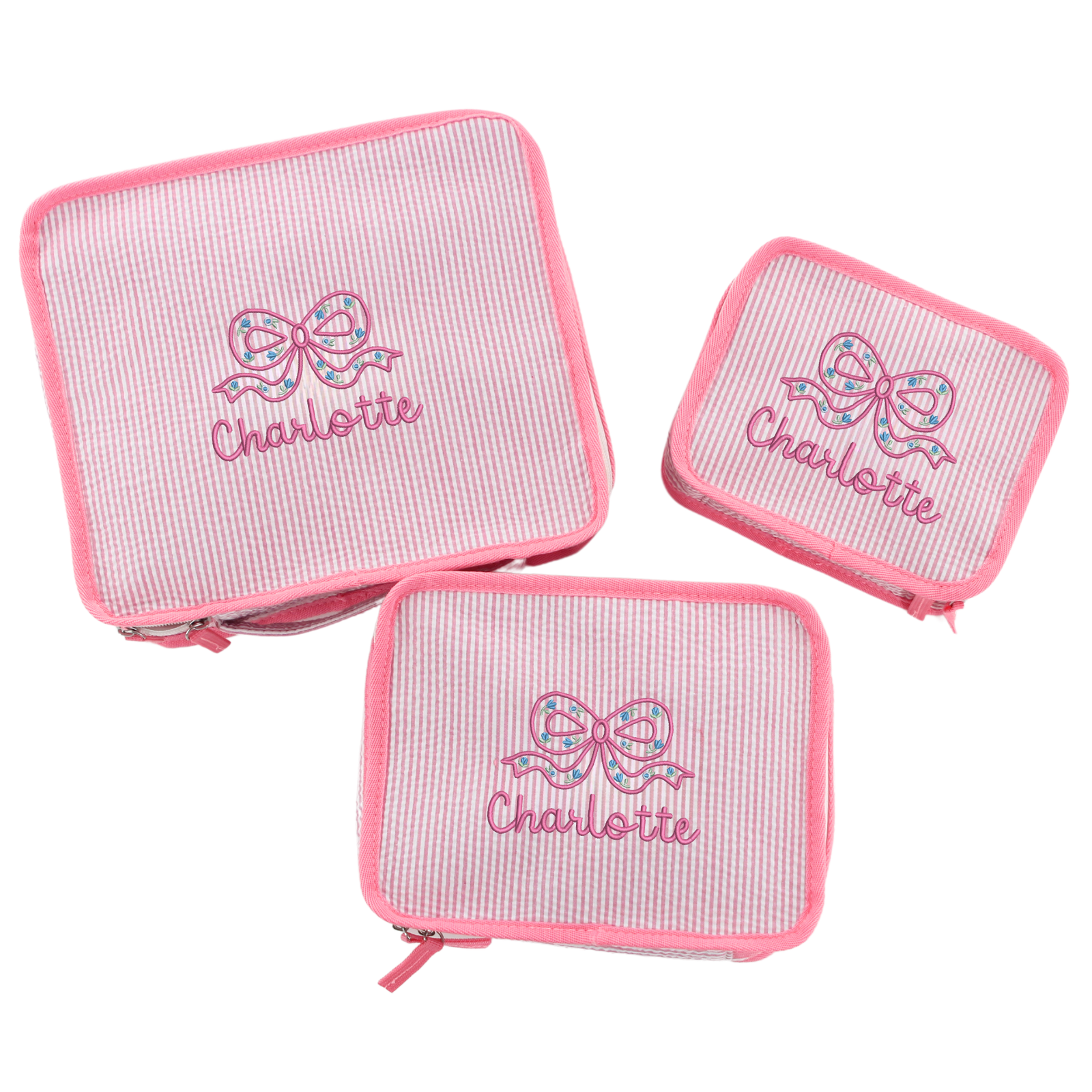 Three pink seersucker pouches with bow designs and the name 'Charlotte' embroidered in pink.