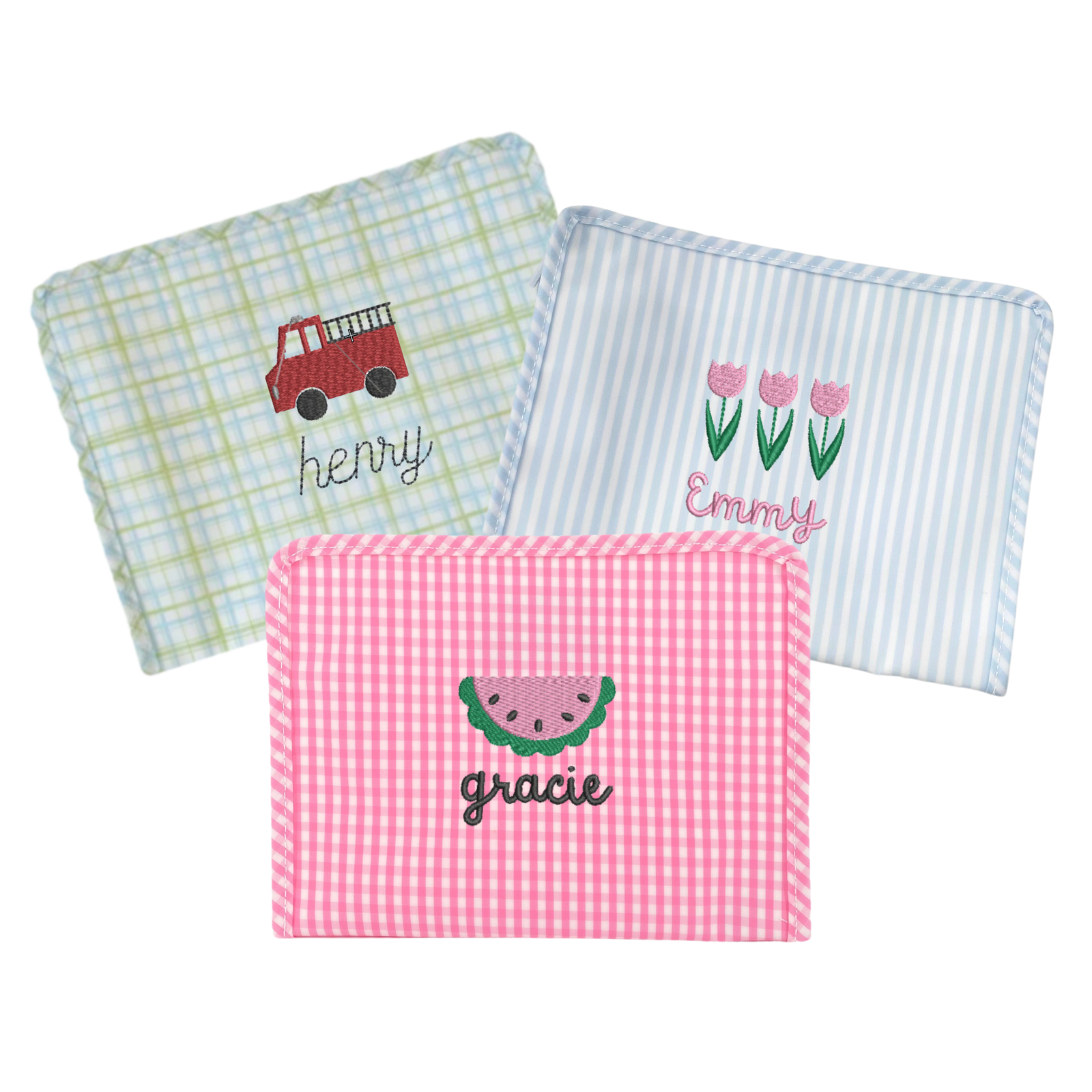 A personalized TRVL plaid bag, blue-striped and a pink gingham TRVL.