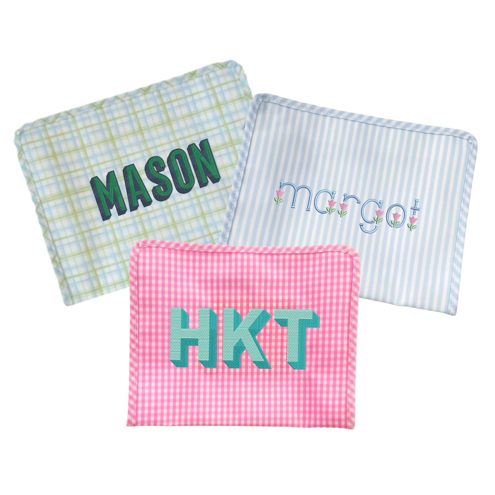 Three personalized bags: a plaid, a blue-striped bag and a pink gingham bag.