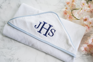 White hooded towel with blue gingham trim and 'JHS' monogram embroidered 
