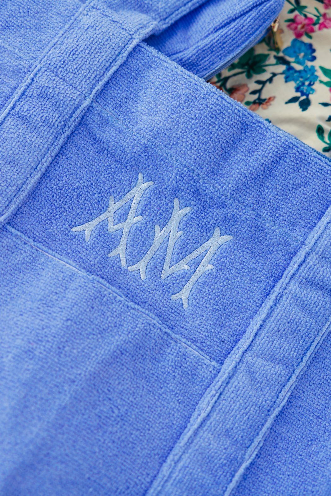 Close-up of a soft, sky blue embroidered terry bundle tote featuring elegant custom monogram initials stitched in tonal thread. Crafted from absorbent terry cloth, this stylish and functional bag is perfect for poolside lounging, spa days, or beach outings—combining plush texture with personalized charm.