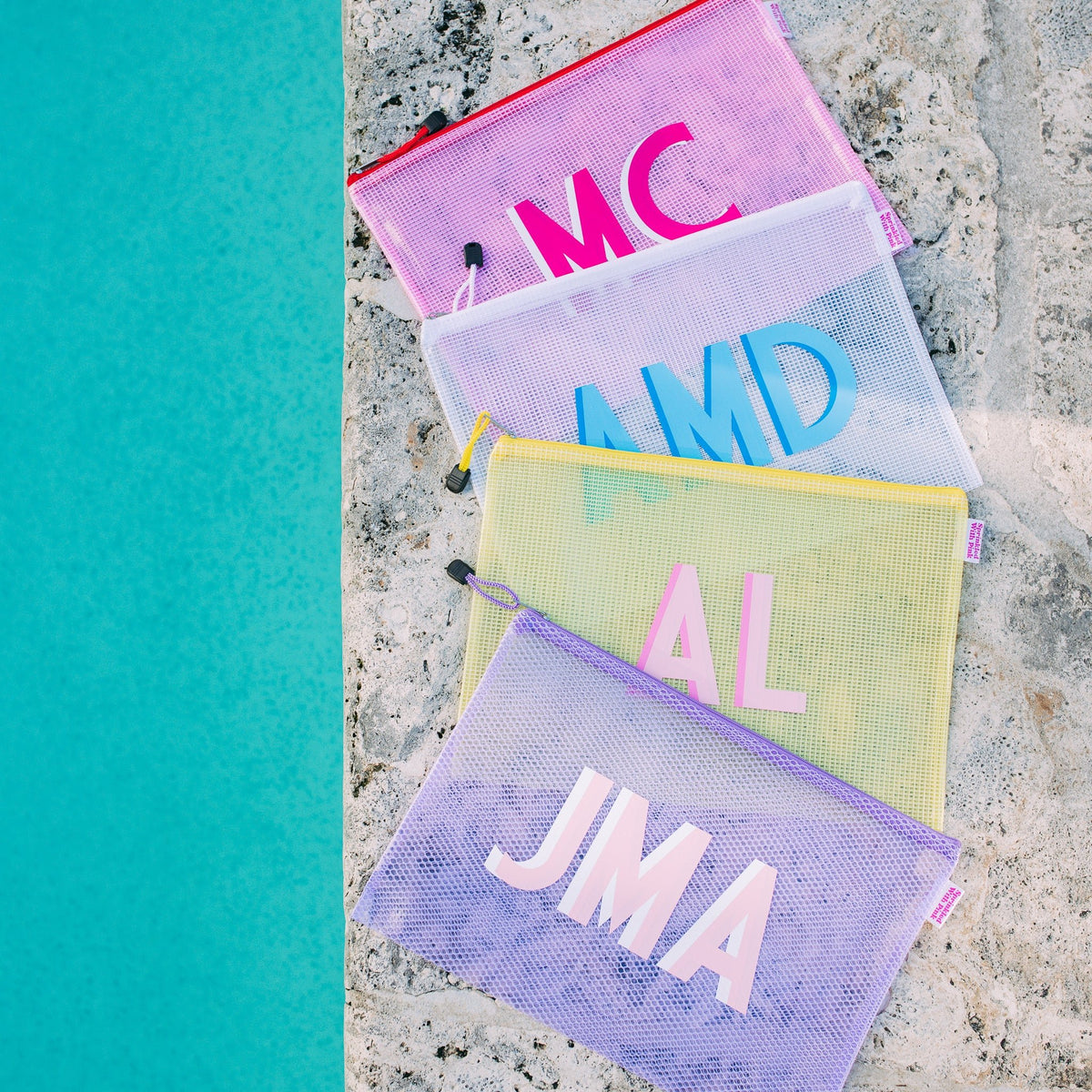 Five clear pool bags with colorful zippers and monograms